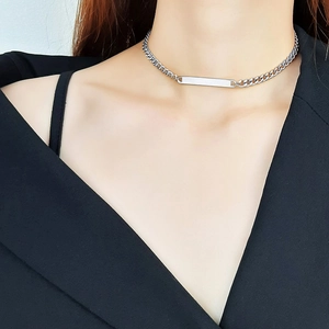 Detail of silver stainless steel bar pendant necklace on a model with black clothing
