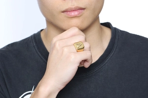 Close-up of a gold stainless steel Freemasonry signet ring showing the compass and square
