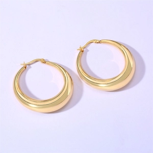 Détail macro de boucles d'oreilles créoles dorées épaisses avec finition 18K polie