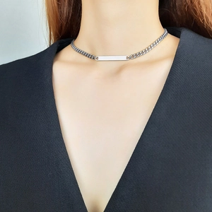 Close-up of minimalist stainless steel bar necklace worn by a model on a black outfit