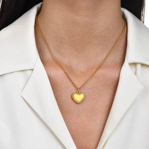 Elegant gold-tone stainless steel heart pendant necklace on model with white shirt
