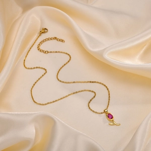 Détail du collier pendentif tulipe doré avec zircon rouge sur satin champagne