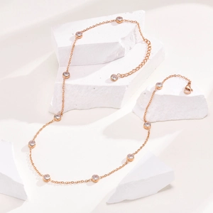 Detailed close-up of rose gold titanium necklace with white zircon bezel setting and lobster clasp