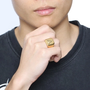 Men's gold stainless steel Freemason square and compass signet ring on a model's hand