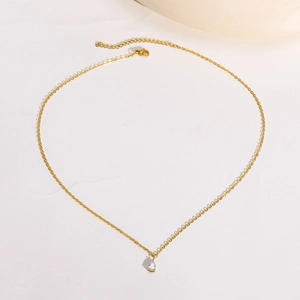 Détail du collier en acier doré avec pendentif en zircone en forme de poire