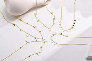 Minimalistische goldene Edelstahl-Halsketten mit Mond-, Herz- und Kreuzanhängern auf Weiß