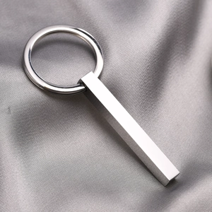 Macro shot of polished stainless steel rectangular keychain on dark grey silk background