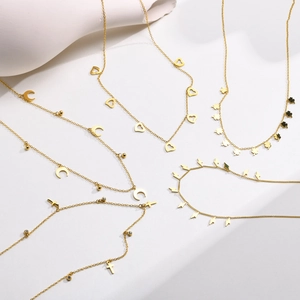 Goldene Halsketten aus Edelstahl mit Kreuz, Mond und Kleeblatt Anhängern auf Steindekor