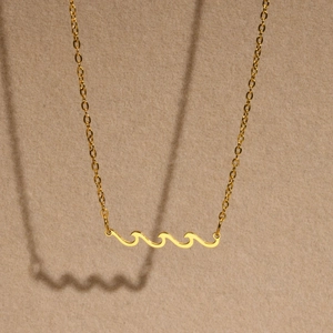 Minimalist gold wavy necklace for women with polished wave pendant and fine link chain