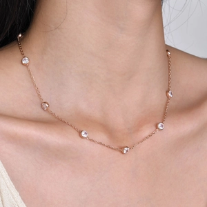 Close-up of rose gold stainless steel necklace with sparkling round zircon stones on a model