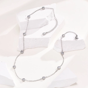 Detailed view of silver titanium necklace with white zircons on white gypsum blocks