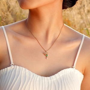 Dettaglio della collana con zircone a cuore verde e catena d'oro indossata all'aperto