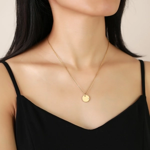 Gold stainless steel necklace with round pendant and zircon worn by a model