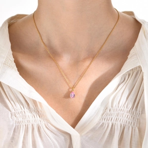 Collier avec pendentif zircon rose en forme de poire sur chaîne dorée porté par un mannequin