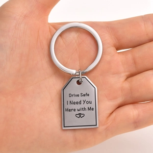 Detailed view of Drive Safe engraved stainless steel keychain held in a person's palm