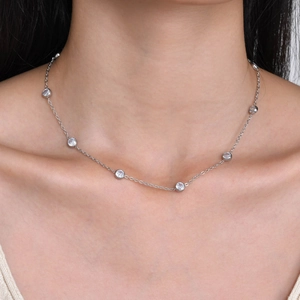 Detail view of minimalist stainless steel necklace with bezel-set round zircons on model