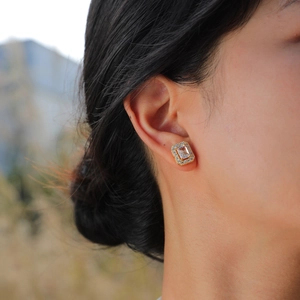 Elegant 15K gold rectangular halo stud earrings with cubic zirconia on a model ear
