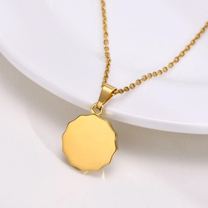 Vue macro d'un collier doré en acier inoxydable avec pendentif rond ondulé poli