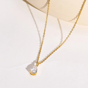 Collier en acier inoxydable doré avec pendentif en zircone poire sur surface texturée