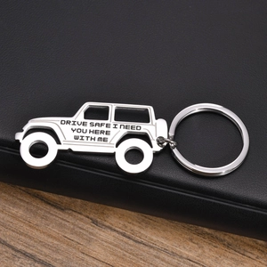 Macro shot of stainless steel car-shaped keychain with engraved Drive Safe message