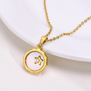 Détail macro du pendentif étoile dorée avec incrustation de nacre et zircon sur chaîne