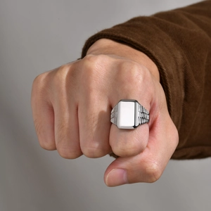 Dettaglio di un anello a sigillo quadrato da uomo con scanalature su un pugno