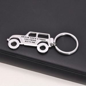 Macro detail of polished stainless steel off-road car keychain with Drive Safe engraving