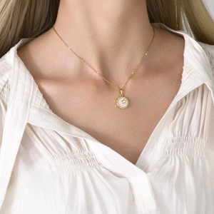 Détail du collier doré avec pendentif étoile en nacre porté par le mannequin