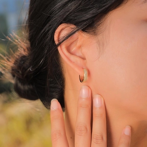 Close-up of 18K gold plated huggie earrings with micro-pave white cubic zirconia stones