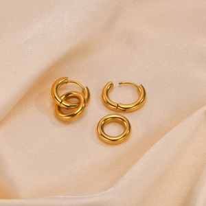 Minimalist double layer golden hoop earrings displayed on elegant silk fabric background