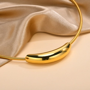 Close-up of a polished gold curved tube pendant necklace on a champagne satin background