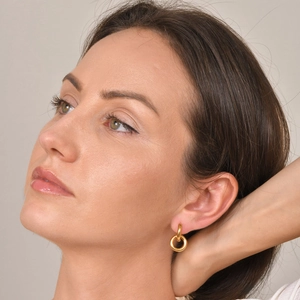 Close-up of golden double hoop earrings on model showing size and polished finish