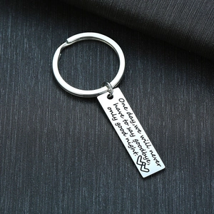 Close-up of a stainless steel rectangular keychain with engraved romantic quote and red hearts