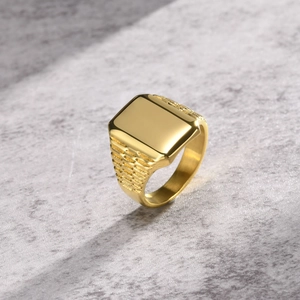 Macro di un anello da uomo a sigillo quadrato dorato su una superficie in pietra