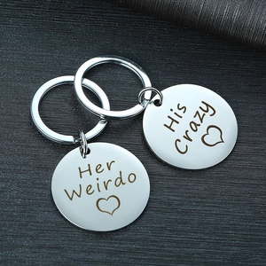 Macro shot of silver stainless steel couple keychains with Her Weirdo and His Crazy engraving