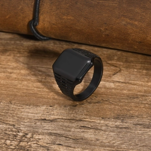 Dettaglio dell'anello quadrato nero opaco da uomo su una superficie in legno scuro