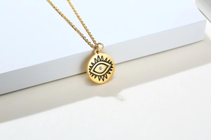 Détail du collier doré en acier inoxydable avec pendentif œil bleu serti de zircon