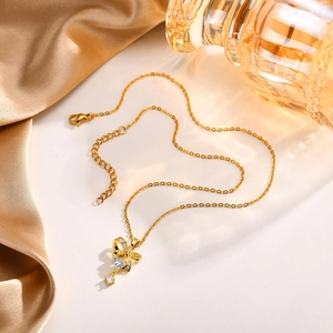 Dettaglio della collana con ciondolo a cuore e fiocco dorato con zircone su seta