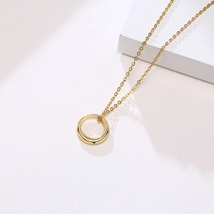 Gros plan d'un collier cercle doré poli minimaliste avec une chaîne à maillons fins sur blanc