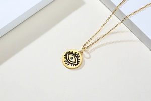 Détail du collier en acier doré avec pendentif œil de démon serti de zircon bleu