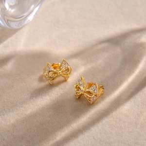 Détails des boucles d'oreilles nœud doré ornées de cristaux de zircone scintillants