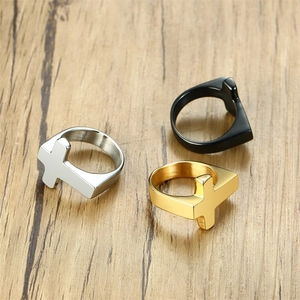 Close-up of titanium steel cross rings in silver, gold, and black on a wooden surface
