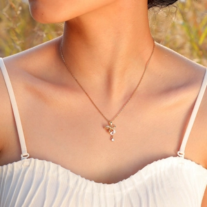 Dettaglio di una collana con ciondolo a cuore in zircone dorato indossata da una modella