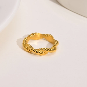 Detailed close-up showing the twisted rope texture on a golden stainless steel ring