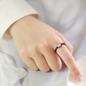Anello con perline nere e zircone a forma di cuore indossato sulla mano di una modella