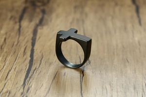 Detailed macro view of the matte black stainless steel cross ring for men with smooth edges