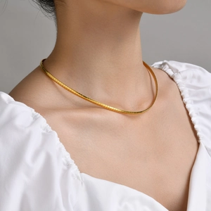 Minimalist gold snake chain choker necklace for women shown on a fashion model