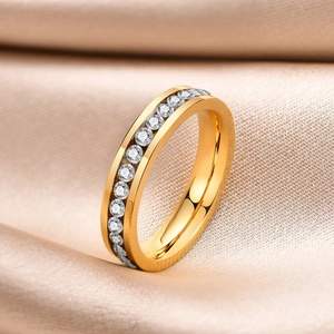 Detail of gold-plated stainless steel eternity ring with white zircons on champagne silk