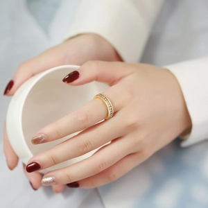 Detail of a thin gold-plated ring with a channel setting of sparkling zircon stones