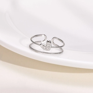Detailed macro view of silver heart ring with beaded edge and double layer open design